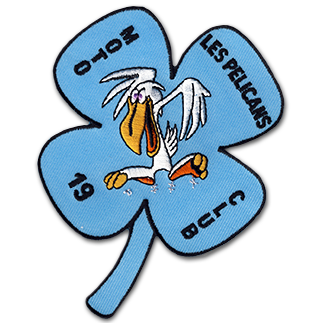 Ecusson brodé du club de moto des pélicans. Il représente un dessin humoristique de pelican, pattes écartées et gueule ouverte. le tout est brodé sur un trèfle bleu clair, sur lequel est brodé le texte Moto les pelicans, club, 19. L'écusson est découpé à la forme du trèfle.