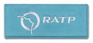Ecusson du logo de la RATP en forme de ticket de métro. l'écusson est aux couleurs de l'entreprise, brodé en blanc sur fond bleu. Il y est brodé le logo et le texte RATP au centre.