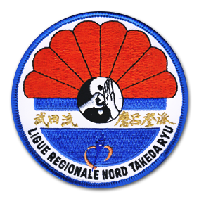 Ecusson rond brodé de la ligue régionale nord de takeda Ryu. Il rerésente en haut une forme de fleur, rognée à l'horizontal. Les pétales sont oranges et le centre est le symbole du ying et du yang avec des mains faisant le salut traditionnel des arts martiaux En bas, un demi cercle bleu traversé d'un bandeau blanc sur lequel des idéogrammes couleur or sont brodés.