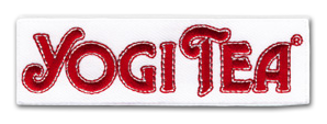 Ecusson brodé de la marque Yogi tea. Il représente le logo de la marque en touge sur un rectangle horizontal blanc.