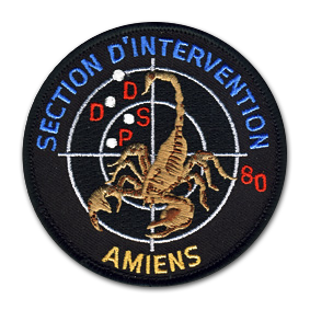 Ecusson rond brodé de la section d'intervention d'amiens, de la direction départementale de la sécurité publique de la police nationale. Il représente un scorpion, la queue en l'air, de face sur une cible blanche sur fond noir. Dans la cible, les lettres DDSP sont brodées en rouge, avec le chiffre 80. En haut de l'écusson, le texte Section d'intervention et en bas : Amiens.