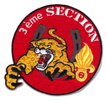 Ecusson rond brodé de la 3ème section de militaires. L'écusson représente un tigre griffes en avant et gueule ouverte traversant un fer à cheval. A droite, la grenade à huit branches jaune se découpe sur le fond de feutrine rouge. En haut, il est écrit 3ème section en blanc.