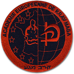 Ecusson de l'académie européenne de Kravmaga. L'écusson est noir et rouge. Le cercle est en deux parties. A gauche, une partie de la carte de france entourée d'étoiles avec un homme bouddhiste au milieu. à droite les traits des méridiens de la terre et un idéogramme. Le tout est brodé en rouge sur fond noir.