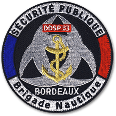 Ecusson de la brigade nautique de Bordeaux. Il représente l'ancre marine sur fond noir et gris, entourée du texte sécurité publique, brigade nautique, ddsp 3 bordeaux.