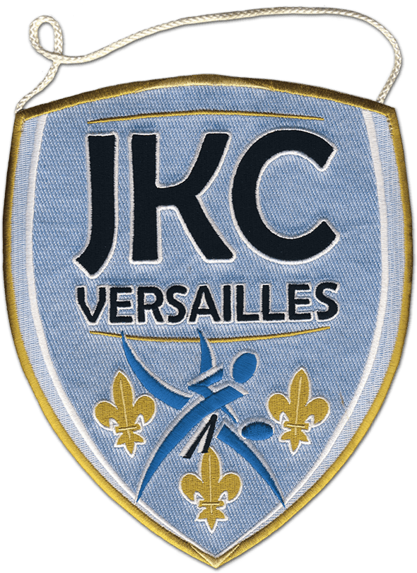Fanion du club de judo ju-jitsu de Versailles. En bas de l'écusson, trois fleurs de lys sont brodées ainsi que deux silhouettes de judoka. Au-dessus, l'inscription JKC Versailles.