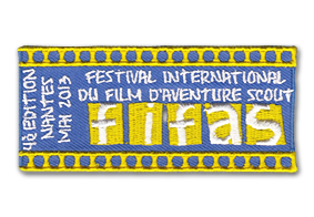 Ecusson rectangulaire horizontal brodé du festival international du film d'aventure scout. L'écusson est jaune et bleu, il est écrit le nom du festival puis et l'acronyme correspondant : FIFAS. A gauche, le texte 4ème édition , nantes, mai 2013. Le bord de l'écusson haut et bas est une broderie type pellicule de cinéma jaune.