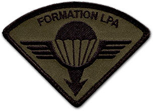 Ecusson brodé de l'armée pour la formation LPA du 1er régiment du train parachutiste. Il a une forme de triangle, pointe vers le bas, arrondi vers le haut. Il a un fond vert foncé, sur lequel est brodé en noir une toile de parachute, avec une flèche vers le bas. De part et d'autre du parachute, des ailes. Au dessus du dessin, le texte Formation LPA est brodé en noir.