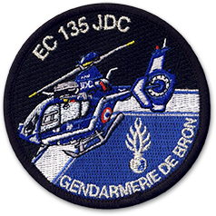 Ecusson brodé rond de la section aérienne de la gendarmerie de Bron. l'écusson représente un hélicoptère sur fond en deux couleurs noir et bleu. En bas à droite, on voit la grenade à huit branches sous laquelle est écrit Gendarmerie de Bron. En haut, est inscrit le texte EC 135 JDC.