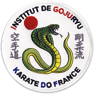 Ecusson brodé de l'institut de Gojuryu, karate do de France. L'écusson représente un cobra vert sur fond blanc avec des idéogrammes de part et d'autre et un rond rouge au-dessis. Le nom de l'institut est noté en haut et en bas de l'écusson.