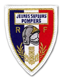 Ecusson brodé des jeunes sapeurs pompiers. Il a une forme de balson et un fond constitué de trois bandes verticales bleu, blanc, rouge. Au dessus, dans un cadre blanc, le texte Jeunes sapeurs pompiers. dessous, au centre de l'écusson, est brodé un casque de pompier entouré des lettres R et F. dessous, deux branches de laurier couleur or.