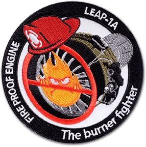 Ecusson de safran pour le test de feu du LEAP 1A. L'écusson brodé rond représente un réacteur sur lequel une flamme avec des yeux est barrée de rouge. Au-dessus, un casque de pompier, et derrière un parachute. Sur le contour de l'écusson, le texte Fire proof engine et the burner fighter.