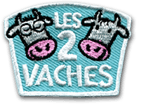 Ecusson brodé de la marque Les 2 vaches. il représente le logo de la marque : sur un fond bleu, deux têtes de vaches sont brodées de part et d'autre du texte Les 2 vaches. Le bord de l'écusson est blanc. L'écusson a une forme rectangulaire horizontale évasée vers le haut.