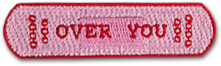 Ecusson brodé de forme rectangulaire aux coins arrondis. Le texte Over you est écrit en rouge, sur fond rose.