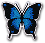 Ecusson brodé personnalisé de très petite taille avec découpe sur mesure représentant un papillon bleu dégradé jusqu'au noir. L'écusson est découpé à la forme du papillon.