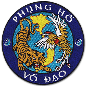 Ecusson brodé rond de l'école de Vo Dao. Il est bleu, avec au centre un tigre et un oiseau sur la forme du Vietnam. Sur la bordure, en haut le texte Phung ho et en bas le texte Vo Dao.