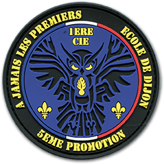 Ecusson PVC rond de l'école de gendarmerie de Dijon. Sur un fond bleu, un hibou stylisé est représenté en noir avec des yeux jaunes et une grenade à huit branches au milieu du poitrail. Au-dessus du hibou, le texte 1ère cie est écrit en jaune. En bas à gauche et à droite du hibou, deux fleurs de lys jaunes. Le bord de l'écusson est un bandeau noir, sur lequel il est écrit la devise à jamais les premiers Ecole de Dijon, 5ème promotion.