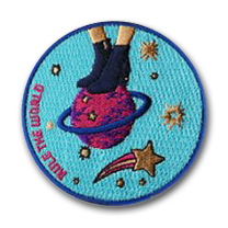 Ecusson pour la marque d'accessoires de mode paper motel. L'écusson brodé en 9 couleurs représente des pieds de femme dans des chaussures à talons surmontant une planète. A gauche, l'inscription Rule the world est brodée en rose.