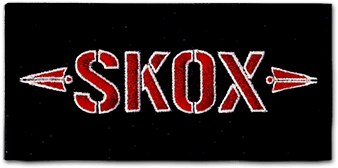 Ecusson du groupe de métal SKOX. L'écusson est rectangulaire horizontal, avec un fond noir sur lequel est brodé le nom du groupe de musique SKOX en rouge, en reoprenant leur logo avec deux petites fleches rouges de part et d'autre.