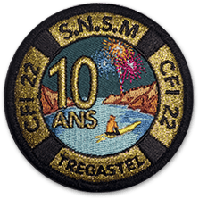 Ecusson rond de la SNSM représentant la mer, des rochers sur les côtés et un homme en kayak. Au loin, on voit un feu d'artifice et sur le dessus du dessin, le texte 10 ans. Sur les bords, en noir sur fond or, le texte suivant est brodé: CFI22, SNSM, Tregastel.