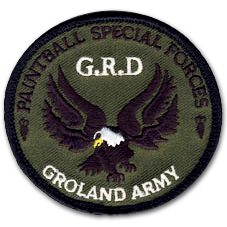 Ecusson brodé rond du club de paintball Groland Army. il a un fond vert foncé, sur lequel un aigle marron au bec jaune est brodé. Au dessus, en noir, le texte Paintball special forces. En blanc, le texte GRD.