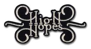 Ecusson brodé découpé en noir et blanc. Il y est écrit high hopes, entouré d'arabesques, en blanc sur fond noir. L'écusson est découpé à la forme du dessin.