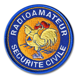 Ecusson rond brodé de la sécurité civile.Il représente un coq jaune à cr^te rouge chantant au dessus d'une antenne radio. Autour, une bordure bleue sur laquelle est brodé en blanc le texte Radioamateur, sécurité civile.