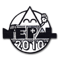 Ecusson brodé des scouts pour l'évènement Népal 2010. Il représente, dans un style naïf, une montagne aux yeux fermées devant levant une main en signe de salut, et devant laquelle le texte nepal 2010 est brodé. L'écusson est rond et la bordure découpe permet de laisser dépasser le texte de part et d'autres.